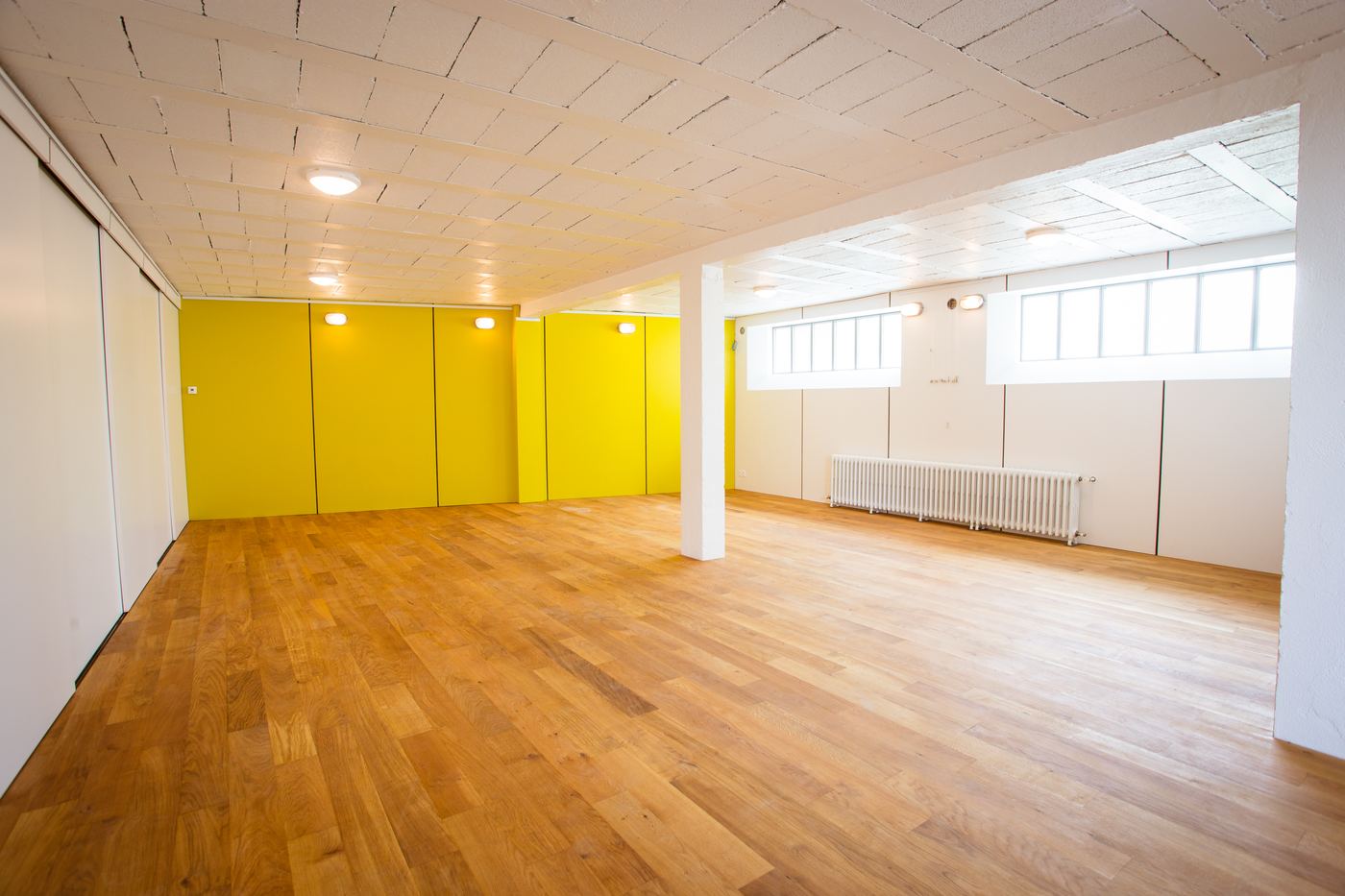 Salle 1 du Plateau 25 — parquet et mur jaune